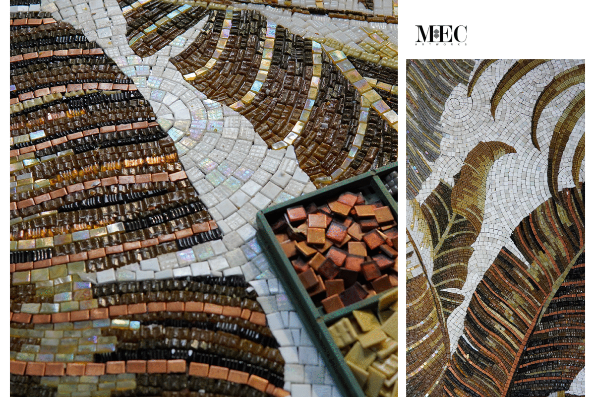 Handcrafted botanical mosaic artwork with warm-toned glass tiles forming textured tropical banana leaves on white.
