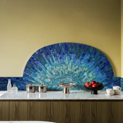Radiant blue mosaic backsplash in a fanburst design with aqua, sapphire, and turquoise tiles, adding ocean-inspired brilliance to a modern interior.