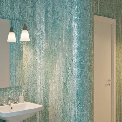 Turquoise and seafoam mosaic wall with vertical pattern flowing along a curved surface, adding texture and tranquility to modern bathrooms.