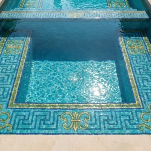 pool with aqua mosaic tiles and Greek key border with gold floral corners, set beside stone deck and formal garden with statues.