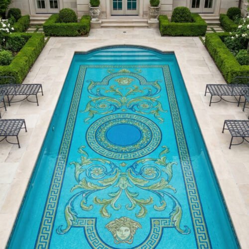 Courtyard pool with classic mosaic medallion and Greek key border in blue and gold, surrounded by stone deck, greenery, and elegant balconies.