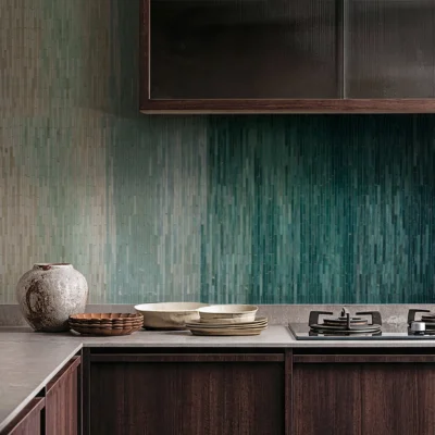 Ombre green linear mosaic tile backsplash with vertical glass strips creating a smooth gradient effect in a modern kitchen interior