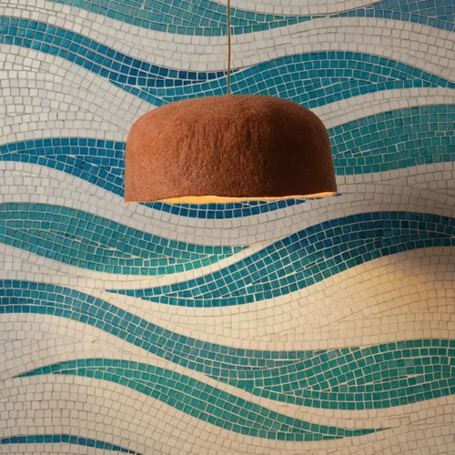 Blue and white wave mosaic tile wall with flowing ocean-inspired pattern and modern pendant light.