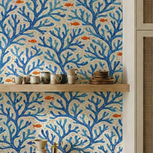 Blue coral reef mosaic wall with small orange fish in a modern kitchen interior.
