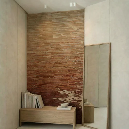 Terracotta ombre stick mosaic feature wall with slim linear tiles, blending beige to warm rust tones in a modern interior setting.