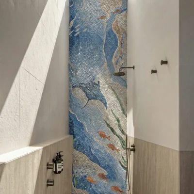 Blue ocean-inspired mosaic shower wall with flowing wave pattern and fish design in a modern bathroom.