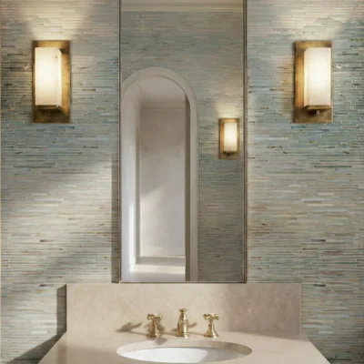 Light blue and aqua linear glass mosaic vanity wall with horizontal tiles, brass wall lights, and stone sink in a luxury bathroom.