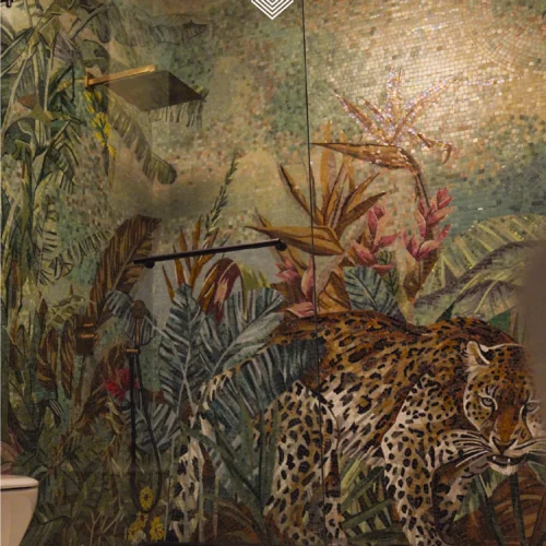 Leopard jungle mosaic mural with tropical foliage and soft sunlight effect in a luxury bathroom.