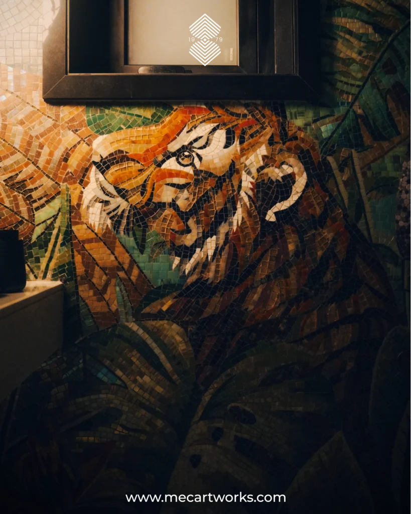Majestic Tiger mosaic mural with jungle leaves in warm orange and green tones installed on a bathroom wall.