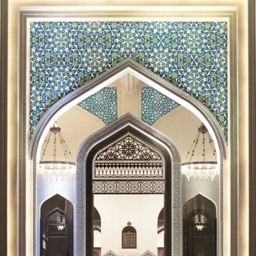 Islamic arch with intricate blue floral and geometric mosaic patterns, showcasing traditional mosque interior design and detailed architectural symmetry.