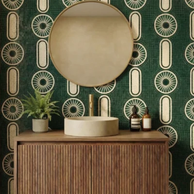 Emerald green mosaic wall with geometric circular and oval ivory patterns behind a modern bathroom vanity.