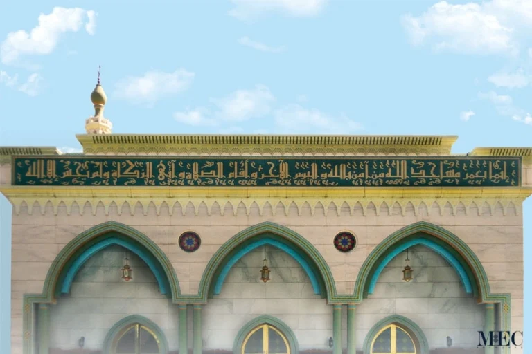 Islamic mosque façade with green mosaic calligraphy band in Arabic script above arched windows, reflecting traditional architectural design.