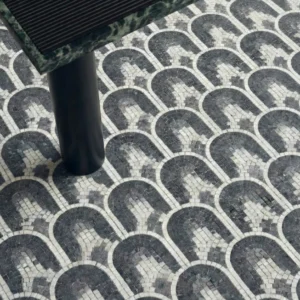 Black and white mosaic tile with repeating arch pattern in a geometric layout.