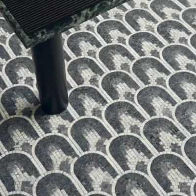 Black and white mosaic tile with repeating arch pattern in a geometric layout.