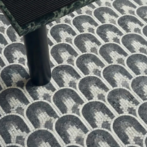 Black and white mosaic tile with repeating arch pattern in a geometric layout.