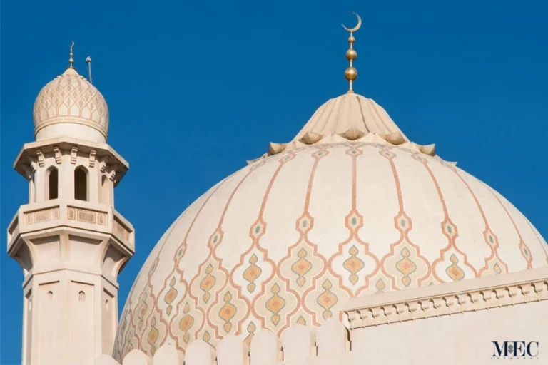 Beige mosque dome with subtle Islamic ornamental mosaic patterns and crescent finial, showcasing elegant traditional architectural design.
