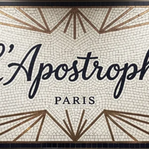Mosaic sign with “L’Apostrophe Paris” text, Art Deco starburst pattern, and ivory background.
