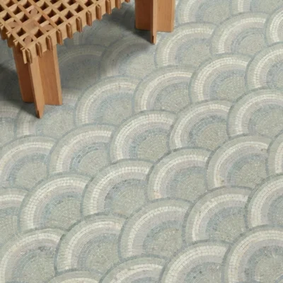 Soft arc mosaic floor design in pale blue, grey, and ivory tones with a repeating curved pattern.