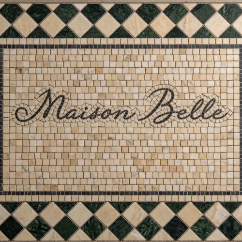 Mosaic tile panel with “Maison Belle” script, ivory background, and green diamond border pattern.