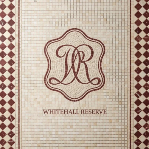 Monogram mosaic tile panel with burgundy initials, geometric border, and ivory background.