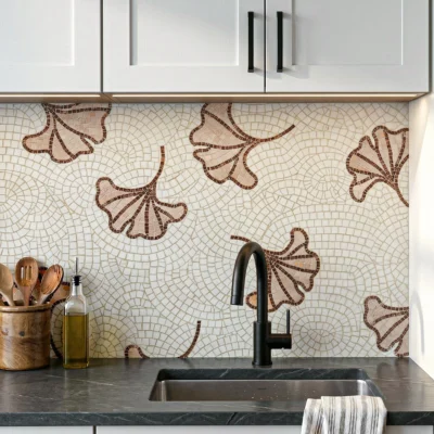 Ivory mosaic backsplash with terracotta ginkgo leaf motifs and flowing geometric patterns in a modern organic design.