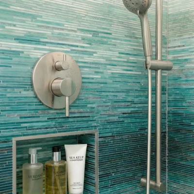 Bathroom mosaic wall tile with layered aqua and deep teal tones in a sleek linear pattern inspired by ocean horizons