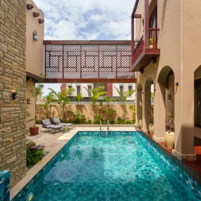 Luxury swimming pool with geometric blue mosaic tiles in aqua and turquoise shades, creating a modern and elegant water effect.