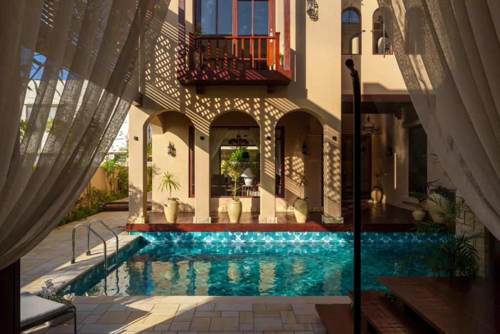 pool with geometric blue mosaic tiles in aqua and turquoise shades, creating a modern and elegant water effect.