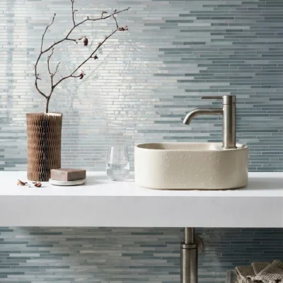 Linear aqua glass mosaic wall tile in soft blue and grey tones creating a calm modern bathroom and spa-inspired interior.