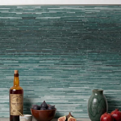Deep sea ombre linear glass mosaic backsplash with teal gradient tones creating a modern luxury wall design for kitchens and baths.