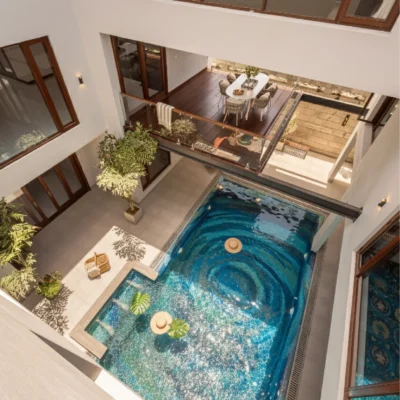 Luxury swimming pool with swirling blue mosaic design inspired by ocean currents, creating a dramatic whirlpool visual effect.