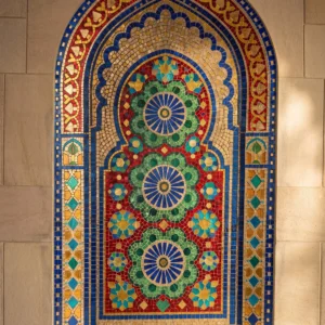Handcrafted Moroccan arch mosaic featuring colorful rosette medallions in blue, green, red, and gold within a traditional Islamic niche.