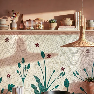 Handcrafted botanical mosaic backsplash featuring green foliage and russet floral accents on an ivory background with flowing mosaic patterns.