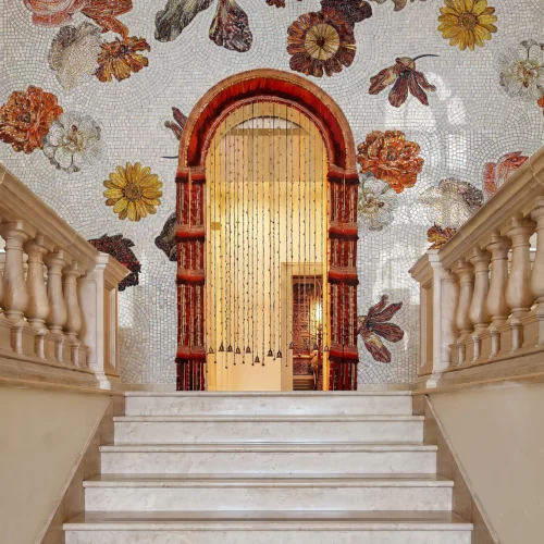 Handcrafted panoramic floral mosaic with oversized autumn blooms in warm earthy tones creating a dramatic luxury architectural feature wall.