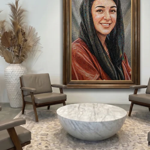 Handcrafted mosaic portrait of Her Excellency Reem Al Hashimy displayed in a refined contemporary executive reception space.