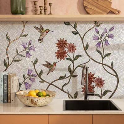 Handcrafted hummingbird mosaic backsplash with flowering vines and botanical details in soft natural tones for a luxury contemporary kitchen.