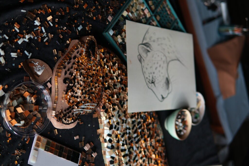 Artisans at work on the leopard glass mosaic