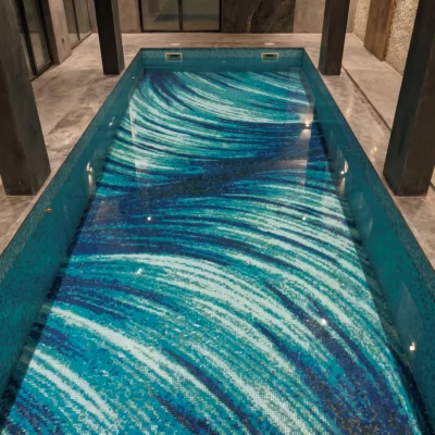 Handcrafted glass and marble pool mosaic featuring flowing blue abstract wave patterns created with individually cut mosaic tesserae.