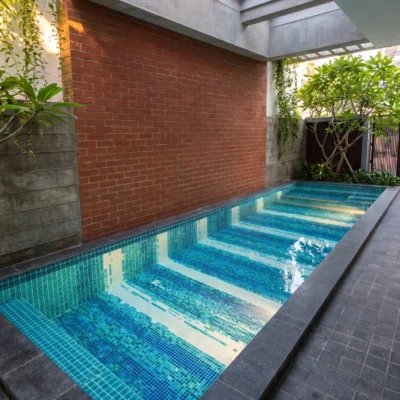 Handcrafted glass and marble pool mosaic featuring flowing blue linear patterns created with individually cut mosaic tesserae.
