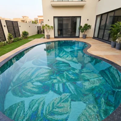 Handcrafted glass and marble pool mosaic featuring tropical palm leaves created with individually cut mosaic tesserae in blue and green tones.