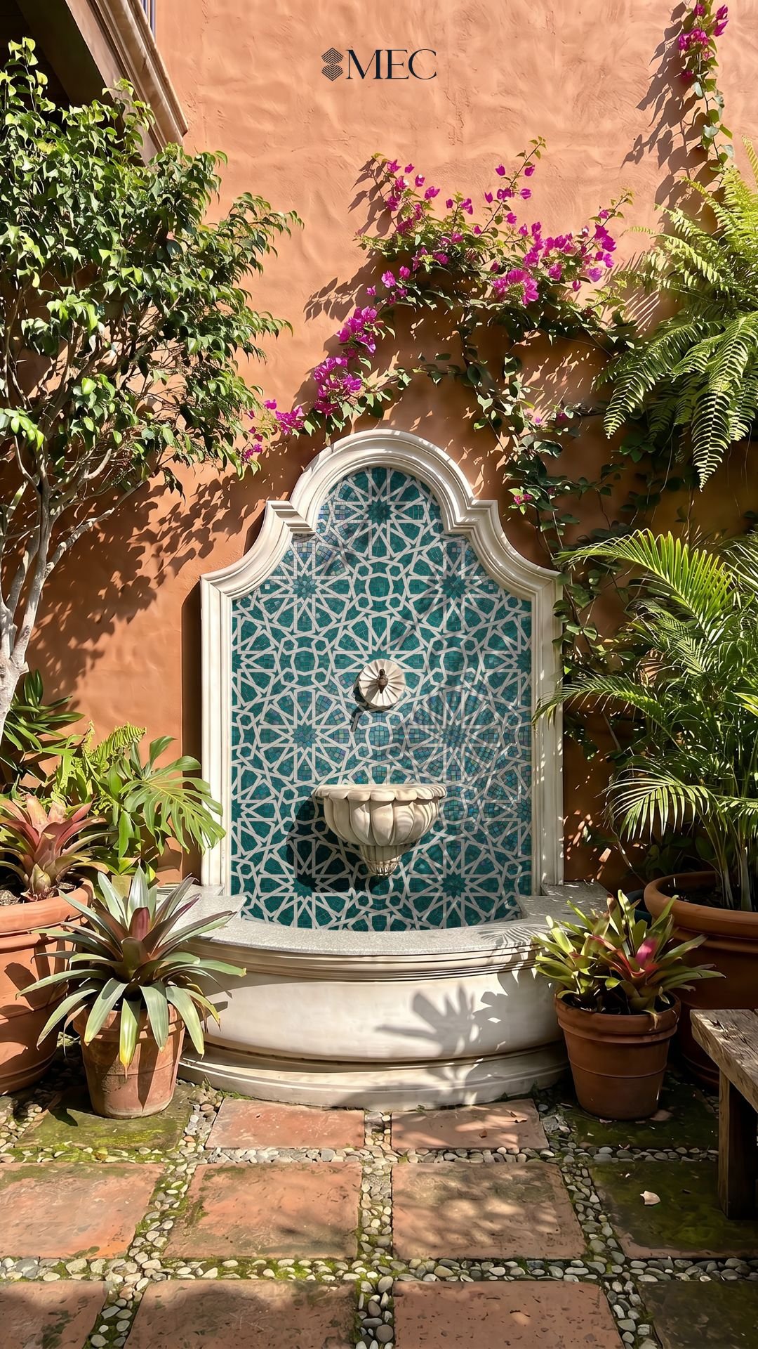 An outdoor wall fountain featuring a teal and white Islamic star mosaic, surrounded by potted plants.