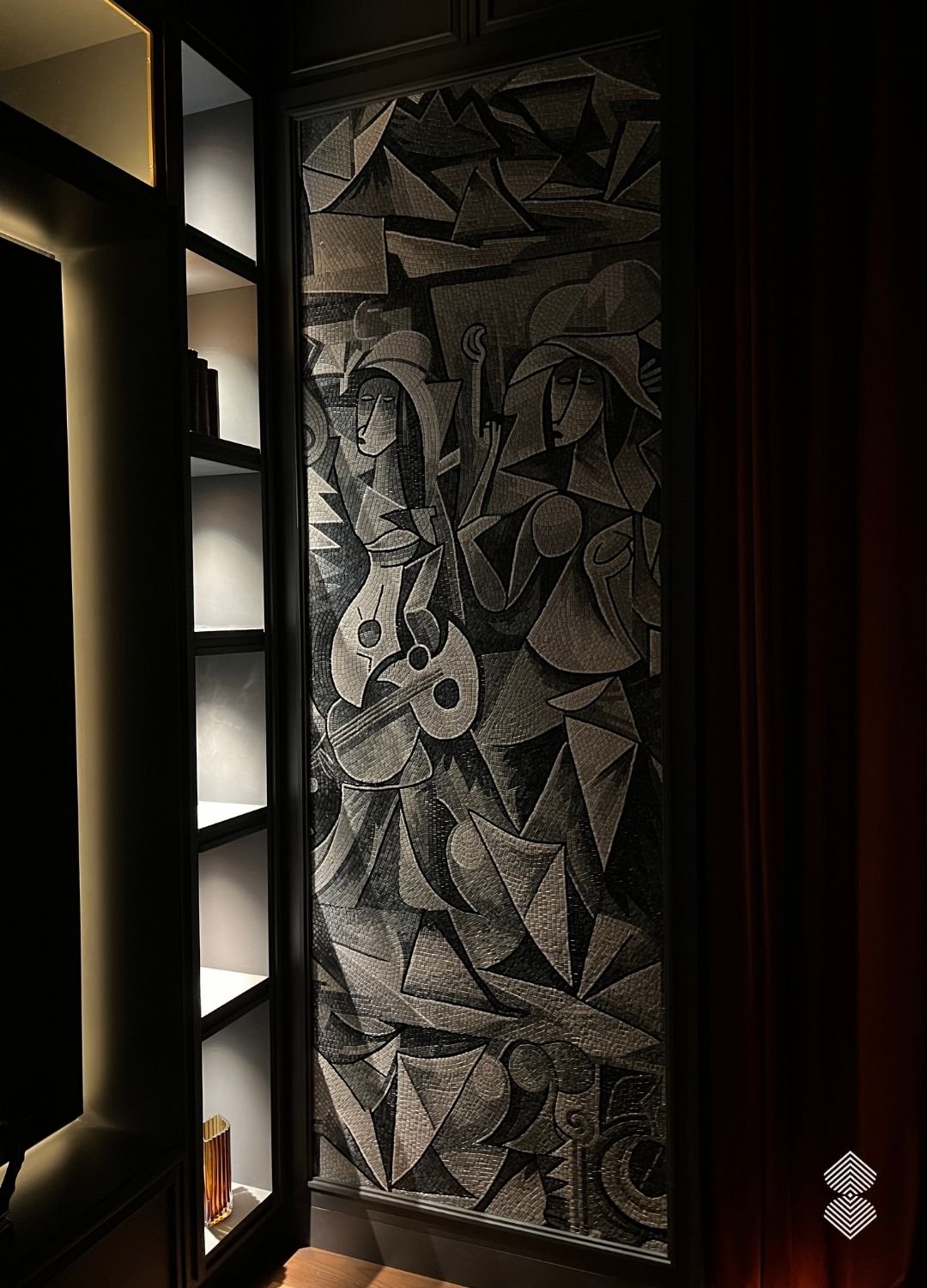 Close-up of a monochromatic, cubist-style mosaic wall artwork depicting stylized female figures in black, white, and grey tiles