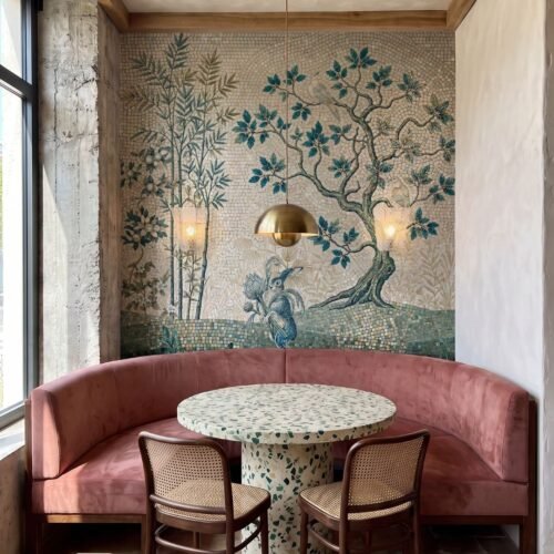 A chinoiserie tree mosaic mural with bamboo, a hare, and a bird covering a cafe accent wall.