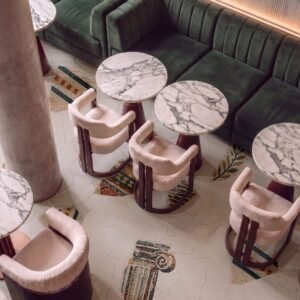 Classical column floor mosaic depicting an Ionic capital fragment set within a stone-paved cafe floor