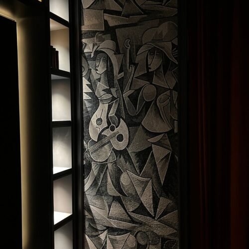 A floor-to-ceiling cubist musicians mosaic mural in gray and black stone tesserae set into a dark wall alcove.