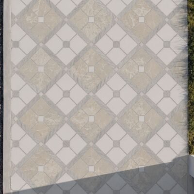 A diamond marble walkway mosaic in cream, beige and gray laid underfoot along a stone path.