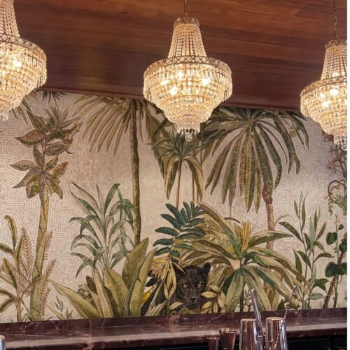 A panther jungle mosaic mural showing a black panther peering through mosaic palm leaves on a cafe wall.