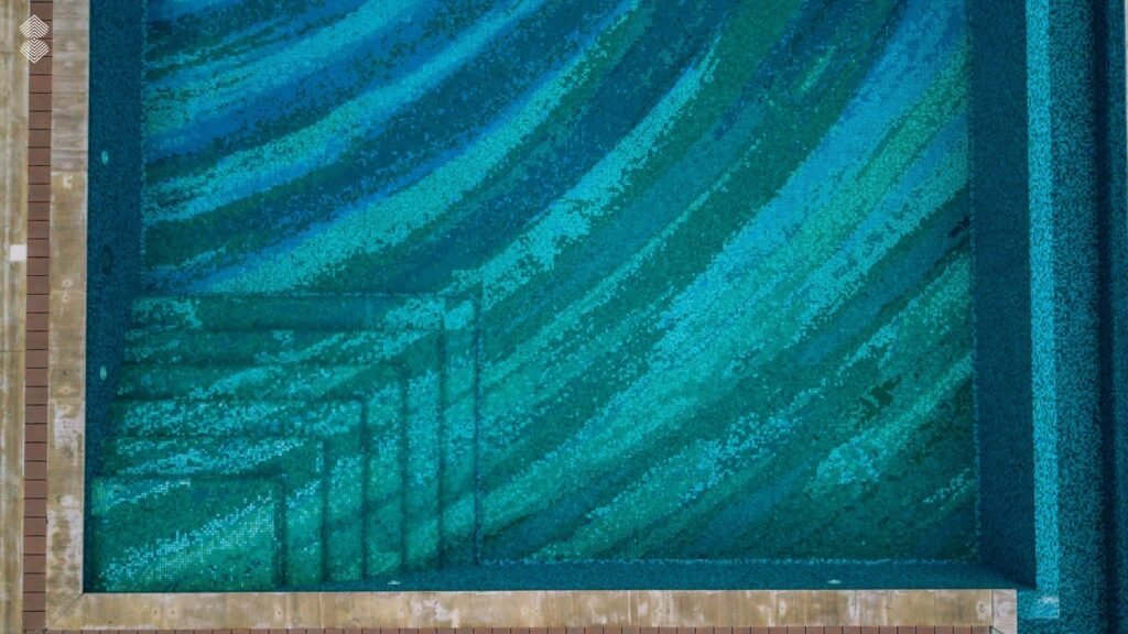 Top-down close view of pool entry stairs seamlessly integrating into the surrounding pixel mosaic pattern.