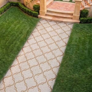 A quatrefoil walkway mosaic in cream and tan stone tesserae laid as a garden path runner