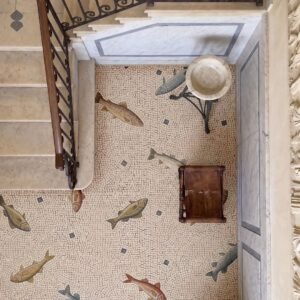 A Roman fish floor mosaic with nine hand cut stone fish scattered across a cream tesserae floor